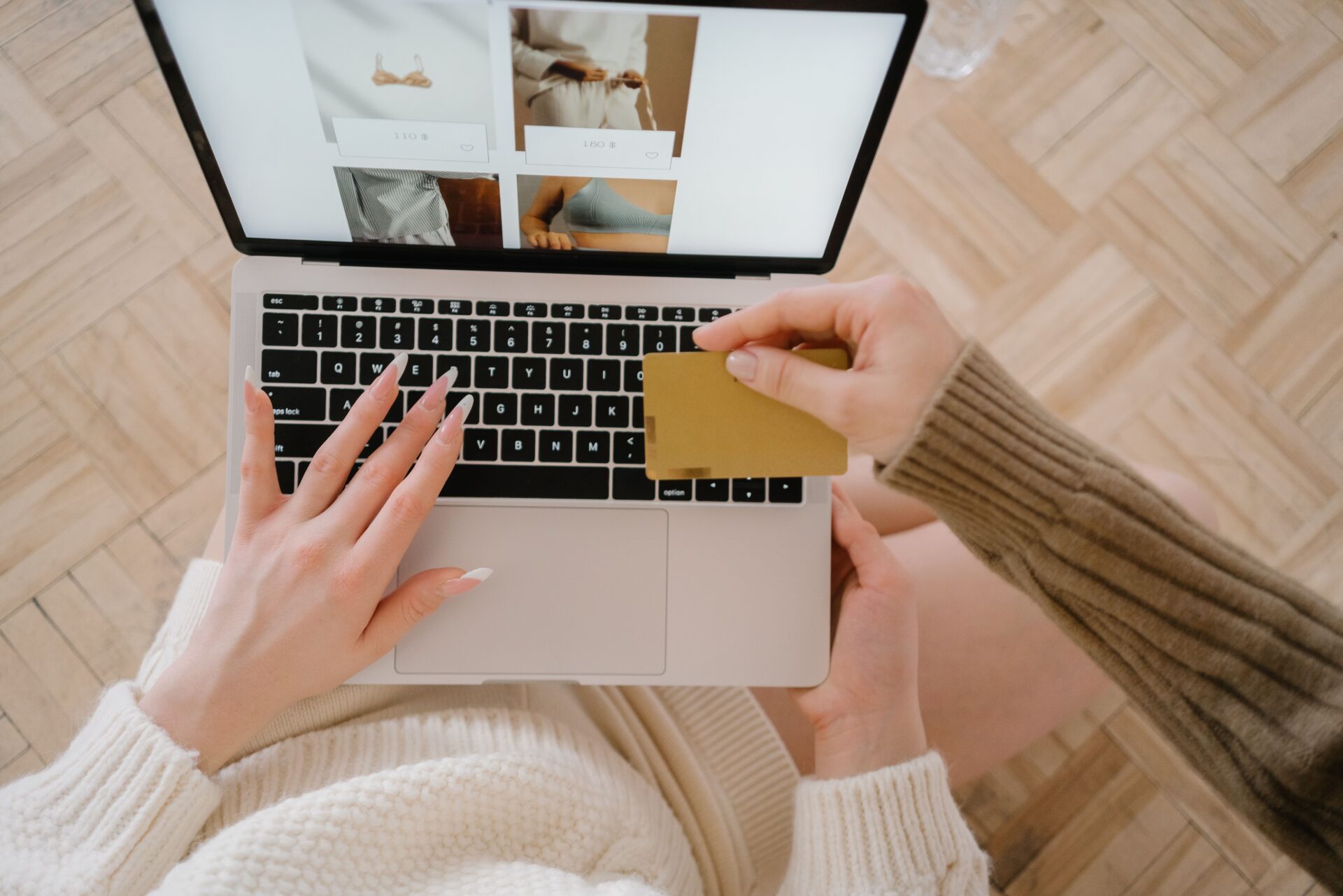 ノートパソコンの通販画面を見ながらクレジットカードを手に購入を検討する人